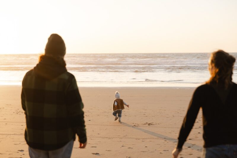 Familie am Strand Kind rennt zum mehr