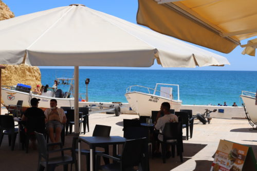Strandcafe mit Schirmen und Blick auf das Meer