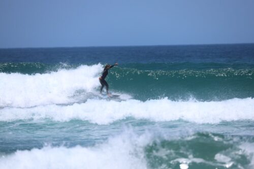 Surferin in Welle in Castelejo